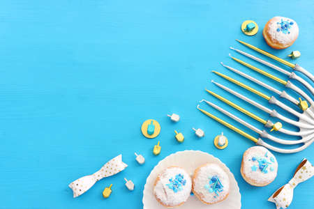 Religion image of jewish holiday Hanukkah background with menorah (traditional candelabra), doughnut...