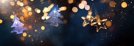 Christmas warm gold garland lights over dark background with glitter overlayの写真素材