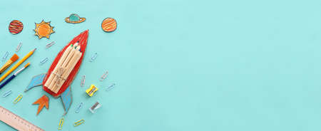education. Back to school concept. rocket cut from paper and painted over blue wooden background....