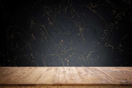 Empty table in front of gold and black marble textured background. For product display montage