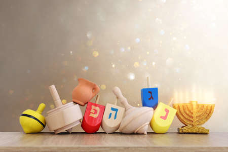 Image of jewish holiday Hanukkah with wooden dreidels collection (spinning top) over glitter backgroundの写真素材