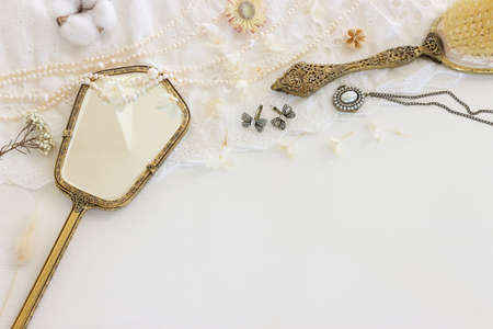 Background of white delicate lace fabric, pearls and vintage hand mirrorの写真素材