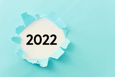 The word 2022 written under blue torn paperの写真素材