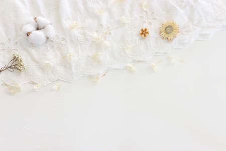 Background of white embroidered delicate lace fabric and dry flowersの写真素材