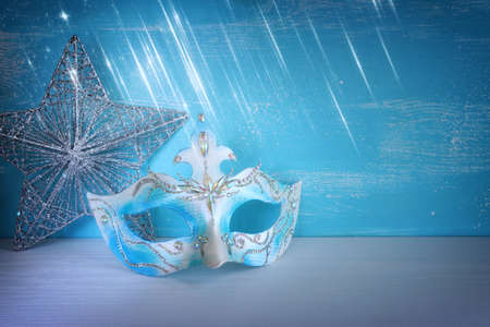 Photo of elegant and delicate Venetian mask over white and blue background. Carnival masquarede and christmas conceptの写真素材