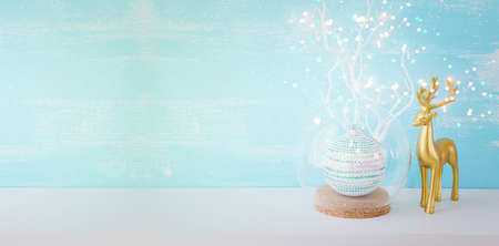 Image of christmas ball and gold deer in front of pastel blue backgroundの写真素材