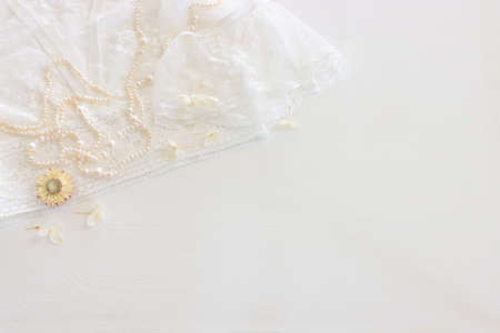 Background of white delicate lace fabric, dry flowers and pearlsの写真素材