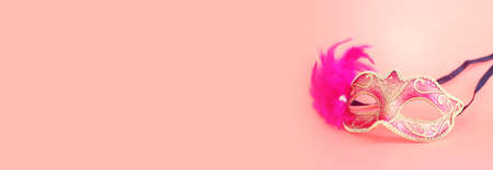 Photo of elegant and delicate Venetian mask over pink backgroundの写真素材
