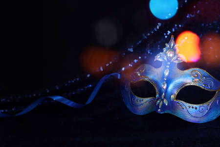 Photo of elegant and delicate Venetian mask over blue dark backgroundの写真素材