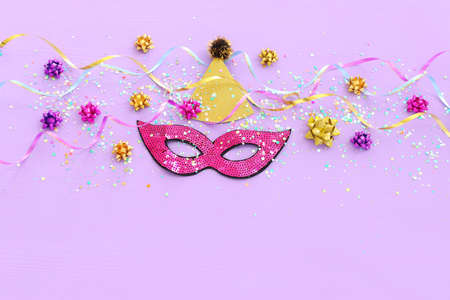 Holidays image of mardi gras masquarade sequins mask over purple background. view from above