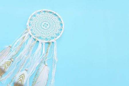 Image of white dream catcher over pastel blue background. Top viewの写真素材
