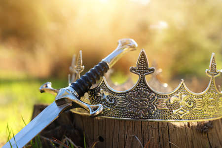 mysterious and magical photo of gold king crown and sword in the England woods. Medieval period conceptの写真素材