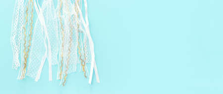Image of white lace ribbons over blue pastel backgroundの写真素材