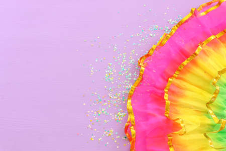 Image of colorful carnival dress over purple background. view from aboveの写真素材