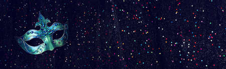 Photo of elegant and delicate Venetian mask over black glitter dark backgroundの写真素材