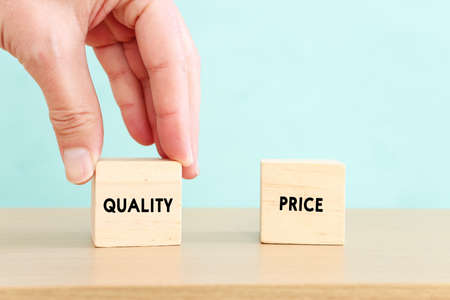 Concept image of quality management and performance with male hand picking wooden cube with textの写真素材