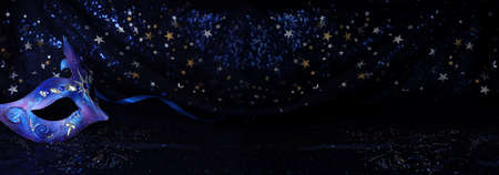 Photo of elegant and delicate Venetian mask over blue dark stars backgroundの写真素材