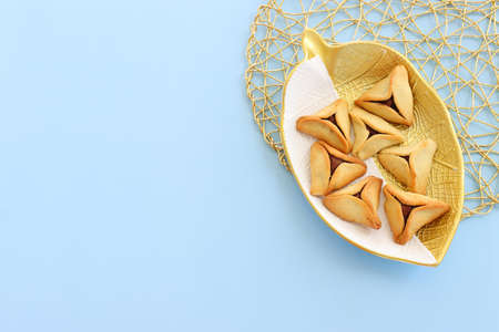 Purim celebration concept (jewish carnival holiday). Hamantaschen cookies over blue pastel backgroundの写真素材