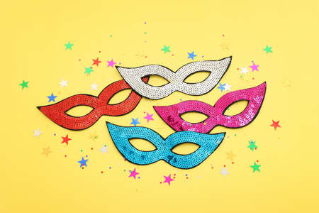 Holidays image of carnival party sequins masks over yellow background. view from aboveの写真素材