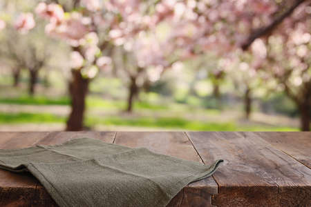wooden table in front of spring blossom tree landscape. Product display and presentation