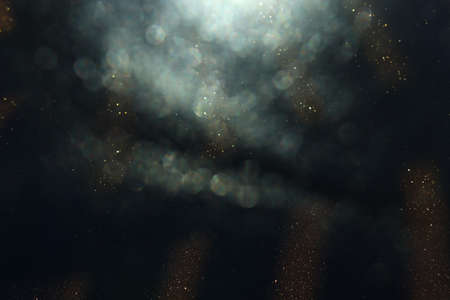 background of abstract glitter lights. gold and black. de focused