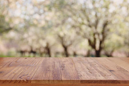 wooden table in front of spring blossom tree landscape. Product display and presentation