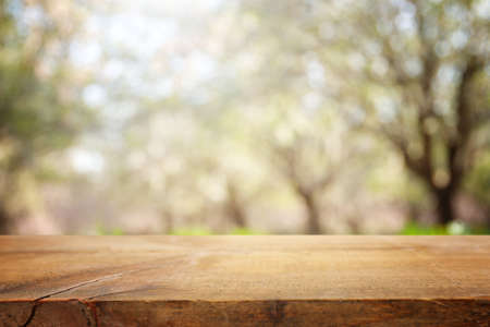 wooden table in front of spring blossom tree landscape. Product display and presentation
