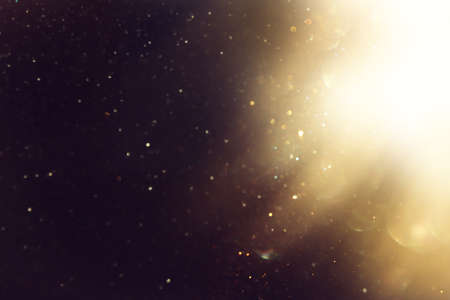 background of abstract glitter lights. gold and black. de focused