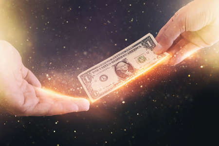 A man holding a dollar bill, concept of payments, spending and receiving moneyの写真素材