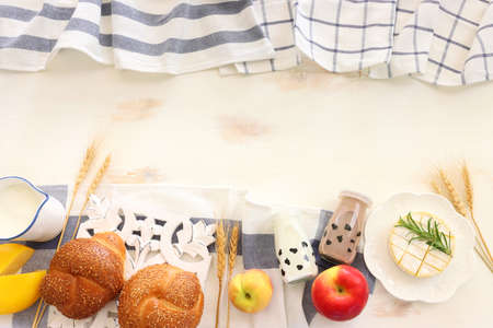 top view photo of dairy products over white wooden background. Symbols of jewish holiday - Shavuot