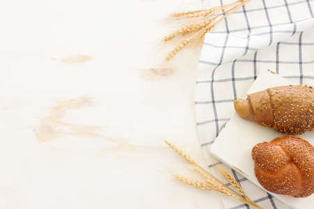 Bread and buns over wooden white background.