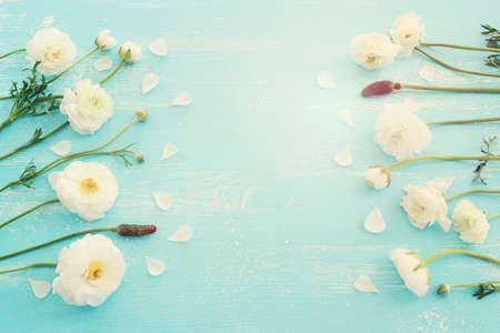 Top view image of white flowers composition over wooden blue pastel background