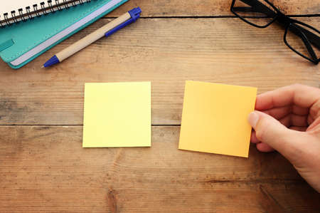 Top view image of wooden office table and black sticky notes