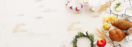 top view photo of dairy products over white wooden background. Symbols of jewish holiday - Shavuot
