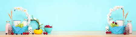 Photo of dairy products over wooden table. Symbols of jewish holiday - Shavuot