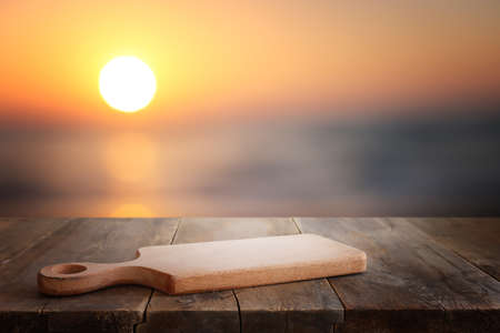 Wooden table and blurred sunset background. Summertime and vacationの写真素材