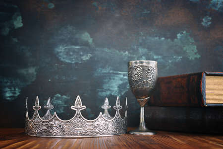 low key image of beautiful queen or king crown and old book. fantasy medieval periodの写真素材