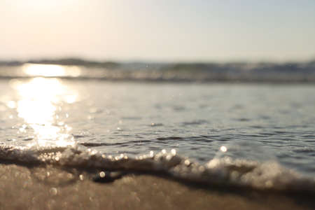 Sea waves and warm sunset light, calm and relaxing sandy beachの写真素材