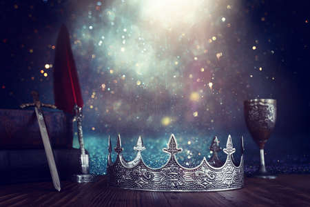 low key image of beautiful queen or king crown next to sword. fantasy medieval period. Selective focusの写真素材