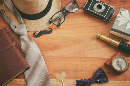 Father's day and travel concept with fedora hat and necktie over wooden background. top view, flat layの写真素材