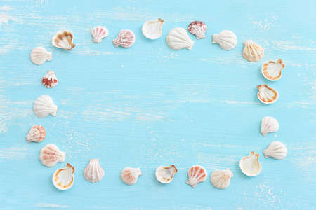 nautical concept seashells and blank board for copy space over blue wooden backgroundの写真素材