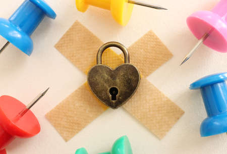 Top view image of locked heart and sharp needles and pins