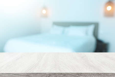 Wooden table and blurred bedroom background, bright morning light. Product display or mock upの写真素材