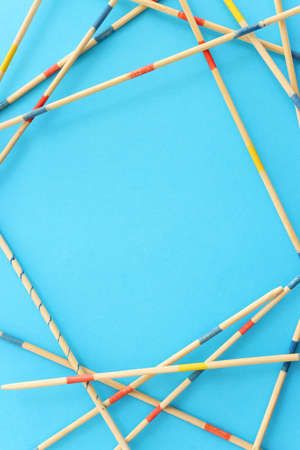 Mikado game over blue background. Wooden sticks that create a graphic image and a geometric frameの写真素材