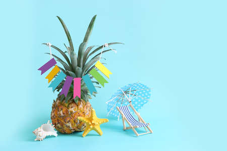 Image with ripe pineapple with parasol and beach chair over blue background. Summer holidays and tropical themeの写真素材