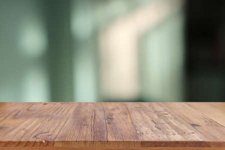 Wooden table and blurred bedroom background, bright morning light. Product display or mock up