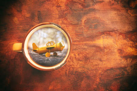 Top view image of coffee mug and vintage airplane over wooden table. Concept of memory, dream, and...