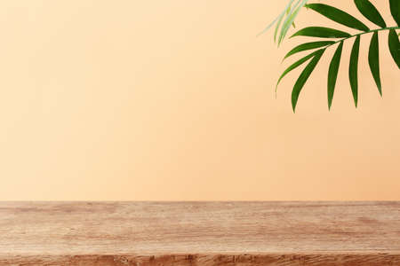 wooden table in front of interior wall and tropical green plant background. for product display and presentation.の写真素材