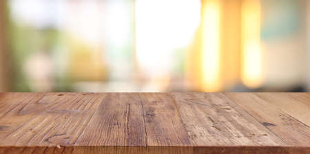 Wooden table and blurred window background, evening sunset light. Product display or mock up