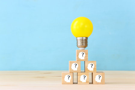 Education and human resource concept image. Creative idea and innovation. light bulb metaphor over blue background, wooden cubes and people iconsの写真素材